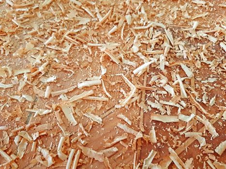 Sawdust on wooden background texture close up.