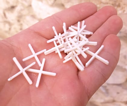 Plastic crosses for laying tiles in the hand.
