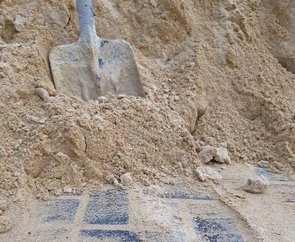 Shovel in the sand. Construction work concept.