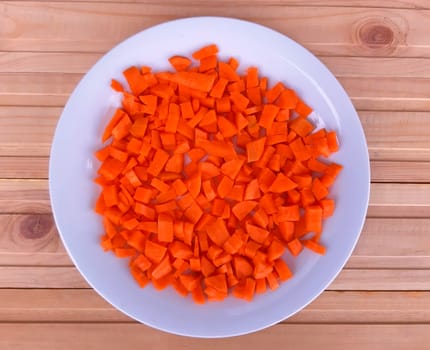 Carrot cut off into a plate on wooden background.