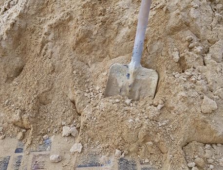 Shovel in the sand. Construction work concept.