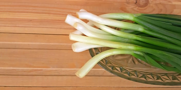 Fresh healthy onion queues on wood background.