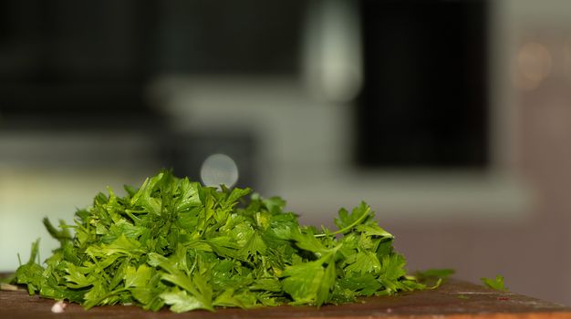 Chopped parsley in the kitchen, cooking process.