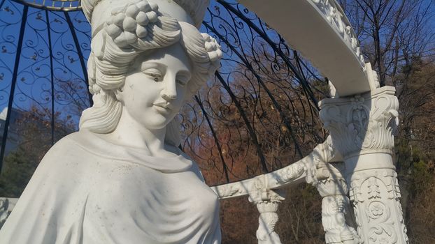 White marble statue of Greek Goddess Head with lovely hair settled in a public park