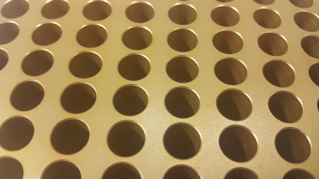 Close up view of holes in golden micro pipette box for scientific research laboratory: Science equipment