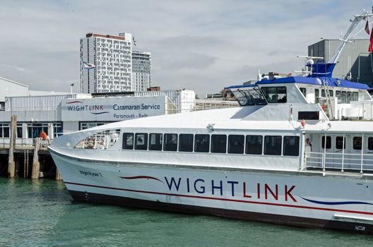 Portsmouth, UK - September 8, 2020: One of the Wightlink passenger catamaran ferries docked at the Portsmouth Harbour terminal on a sunny afternoon on the south coast of Hampshire.  The ferry links Portsmouth to Ryde on the Isle of Wight. 