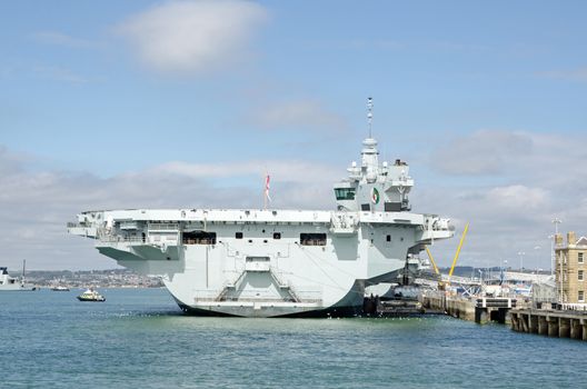 Stern of the massive Queen Elizabeth Aircraft Carrier docked at Portsmouth Harbour, Hampshire.  The Royal Navy ship is the largest in the fleet. 