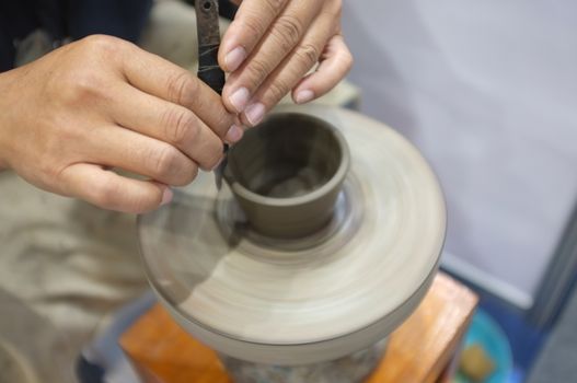 Concept Ceramic workshop. The man Throwing clay bowl on a pottery's wheel.