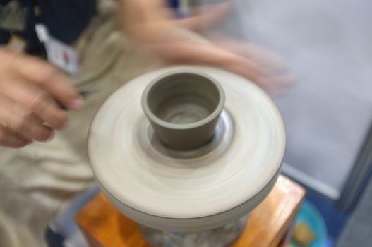 Concept Ceramic workshop. The man Throwing clay bowl on a pottery's wheel.