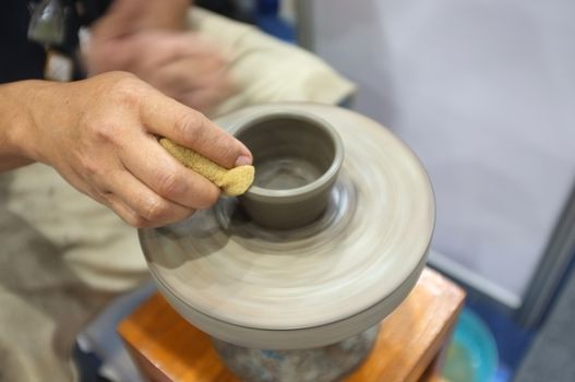 Concept Ceramic workshop. The man Throwing clay bowl on a pottery's wheel.