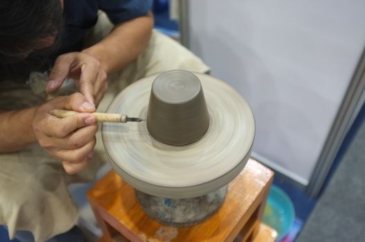 Concept Ceramic workshop. The man Throwing clay bowl on a pottery's wheel.