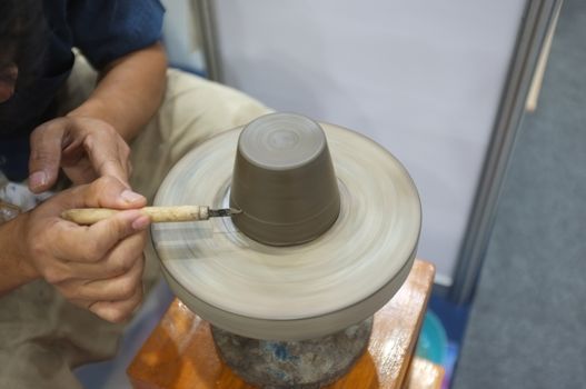 Concept Ceramic workshop. The man Throwing clay bowl on a pottery's wheel.