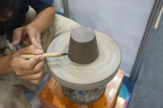 Concept Ceramic workshop. The man Throwing clay bowl on a pottery's wheel.