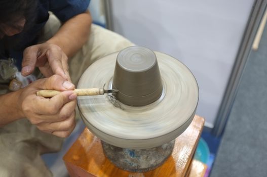 Concept Ceramic workshop. The man Throwing clay bowl on a pottery's wheel.