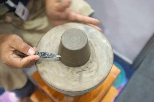 Concept Ceramic workshop. The man Throwing clay bowl on a pottery's wheel.