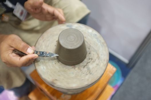 Concept Ceramic workshop. The man Throwing clay bowl on a pottery's wheel.