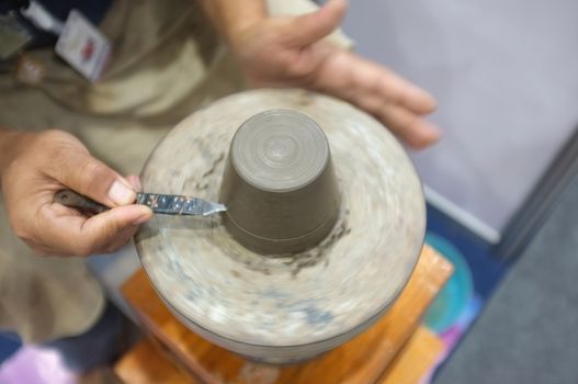 Concept Ceramic workshop. The man Throwing clay bowl on a pottery's wheel.