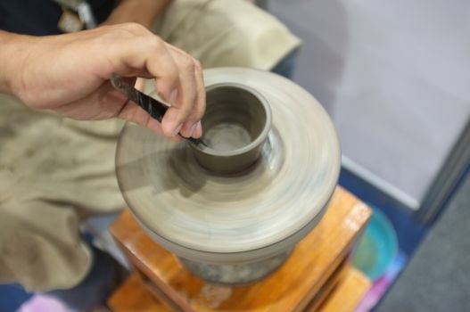 Concept Ceramic workshop. The man Throwing clay bowl on a pottery's wheel.