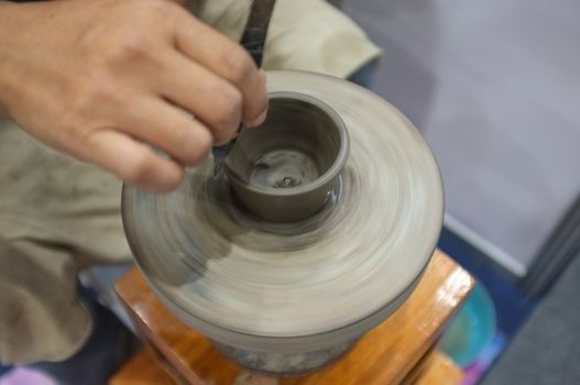 Concept Ceramic workshop. The man Throwing clay bowl on a pottery's wheel.