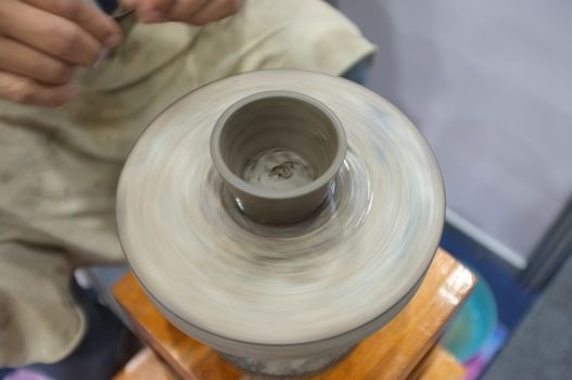 Concept Ceramic workshop. The man Throwing clay bowl on a pottery's wheel.