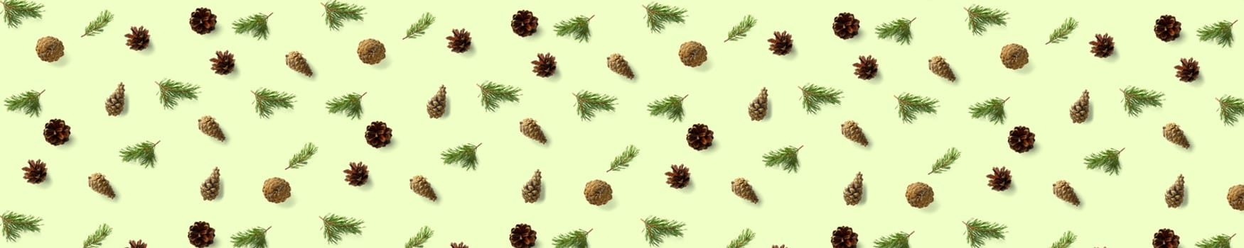 Creative Pine cone Christmas background on green banner. Pine branches and cones. minimal creative cone arrangement pattern. flat lay, top view. new year background wallpaper. Nature pinecone modern christmas panoramic Background