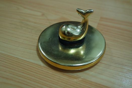 The decorative little golden pot with dolphin lid open, for room decoration. Golden pot on the vintage white background.