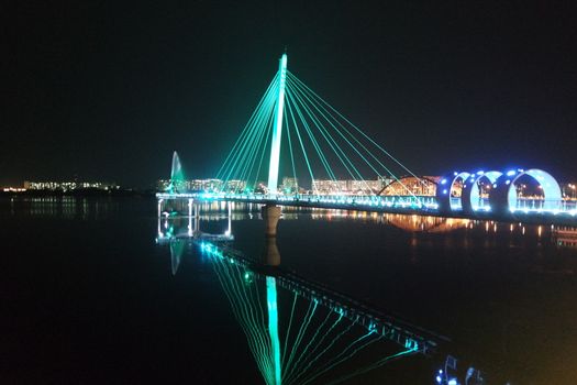 Night view of a beautiful scene of bridge over sea water in the evening time with colorful lights.