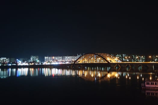 Night view of a beautiful scene of bridge over sea water in the evening time with colorful lights.