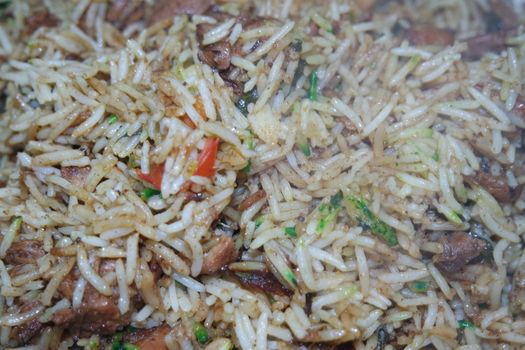 A close up view with selective focus of cooked white Basmati rice pulao or biryani with chicken meat