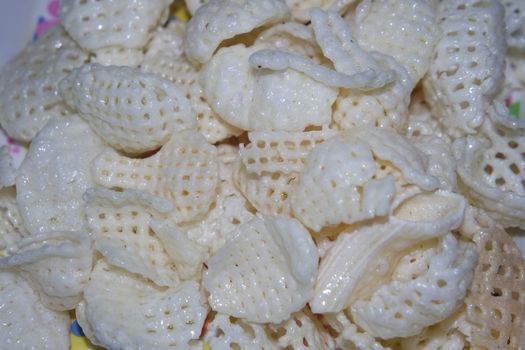 Closeup view of freshly fried chips as fast food for tea break. Potato chips with spices sprinkled on it. Fast food background for advertisements.