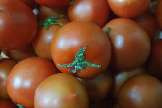 Close-up view of red tomatoes in market for sale. A fruit background for text and advertisements