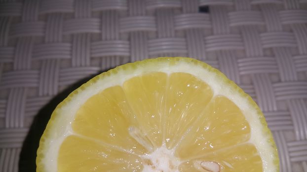 Fresh lemon slices with yellow peelings placed on a grey floor. Top view of fresh juicy lemon slice background