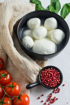 mozzarella buffalo, fresh basil, red tomatoes and olive oil. Italian cuisine, healthy lunch food. Italian caprese salad Ingredients . on cloth and white background.