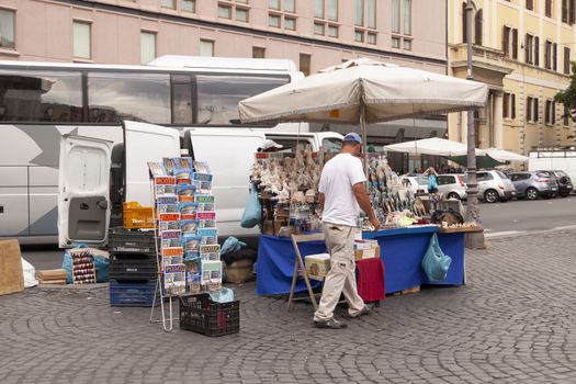 Rome, Italy - June 27, 2010: A man sells souvenirs to the tourists at his street stall, in Rome.