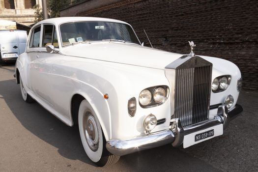 Rome, Italy - June 27, 2010: A luxurious white Rolls-Royce from the 70s, parked on a street in Rome.