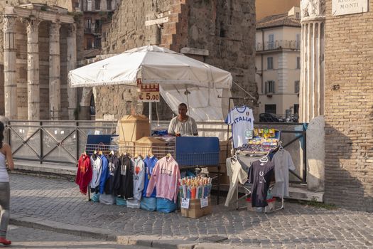 Rome, Italy - June 27, 2010: A man sells T-shirts, sweatshirts and souvenirs to the tourists at his street stall, in the Forum of Augustus area, Rome.