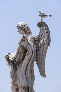 Rome, Italy - June 28, 2010: One of the famous statues of angels, the one with the dices, on the Sant'Angelo bridge near the Castle of the same name.