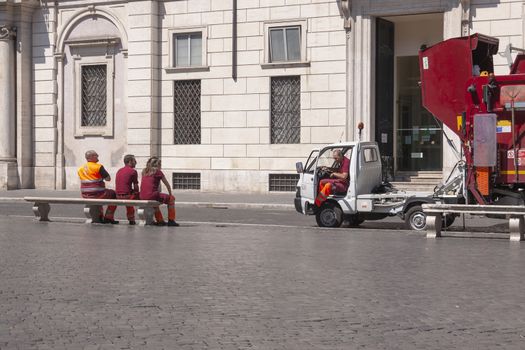 Rome, Italy - June 28, 2010: Workers from the public garbage collection service in Rome sit on a bench in Piazza Navona.