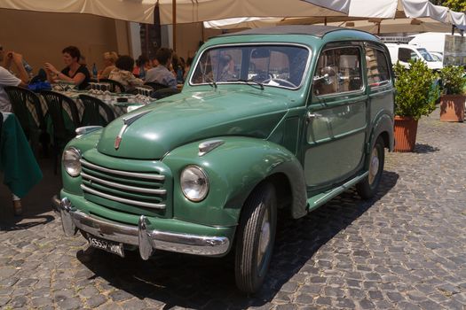 Rome, Italy - June 28, 2010: An old vintage car, Fiat brand, a classic from the 60s, remains parked in one of the central streets of Rome