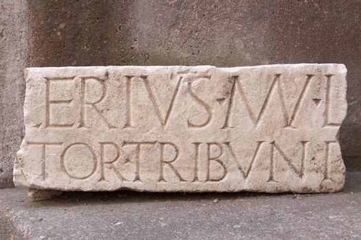 Rome, Italy - June 28, 2010: Ancient Latin inscription, carved from a heavy block of white marble, from the time of the Roman Empire.