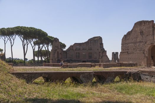 Rome, Italy - June 29, 2010: Some tourists walk near the remnants of the Palatine Stadium, in the area of the Palatine Hill, Roman Forum.