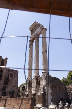 Rome, Italy - June 29, 2010: Remnants of the Temple of Castor and Pollux, with its famous three Corinthian-style columns in the central area of the Roman Forum.