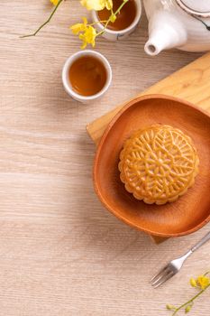 Mid-Autumn Festival holiday concept design of moon cake, mooncakes, tea set on bright wooden table with copy space, top view, flat lay, overhead shot