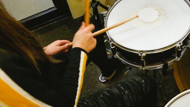 Sticks playing drums on drumkit