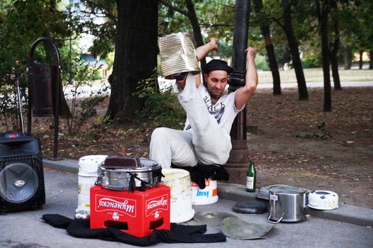 Varna, Bulgaria - September, 06, 2020: street drummer playing in the park with improvised means
