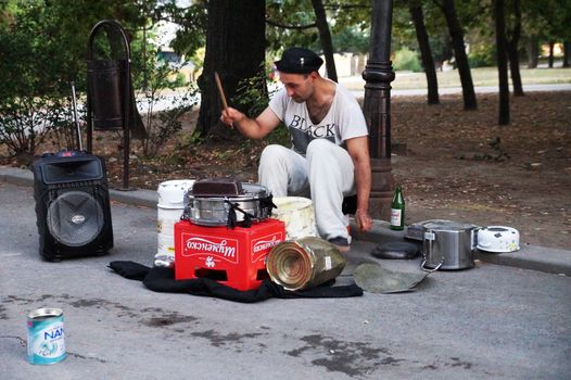 Varna, Bulgaria - September, 06, 2020: street drummer playing in the park with improvised means