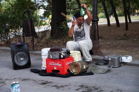 Varna, Bulgaria - September, 06, 2020: street drummer playing in the park with improvised means