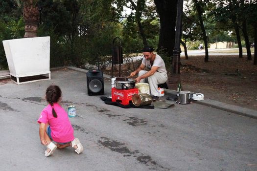 Varna, Bulgaria - September, 06, 2020: street drummer playing in the park with improvised means