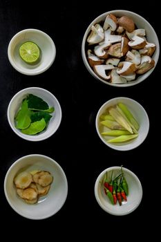 Chili peppers with lime, mint, mushrooms, cucumber, walnut bowl with black background.