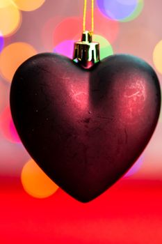 Heart shaped Christmas decoration isolated on blurred background of lights.